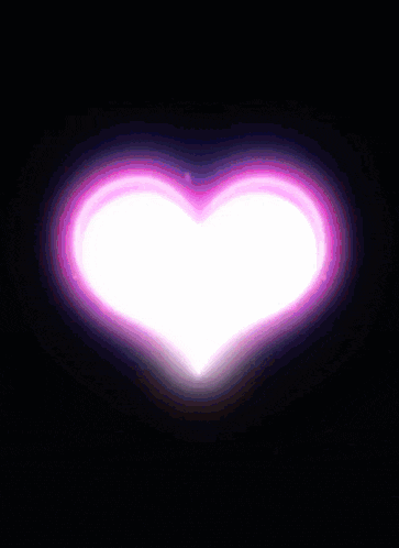 a purple heart shaped light is coming out of a dark background