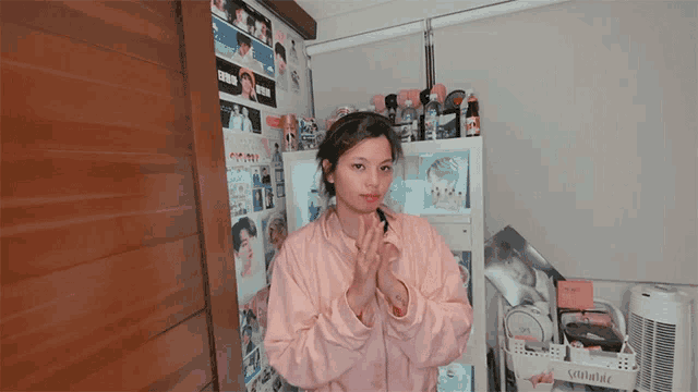 a woman in a pink jacket stands in front of a shelf with a sign that says ' lalala '