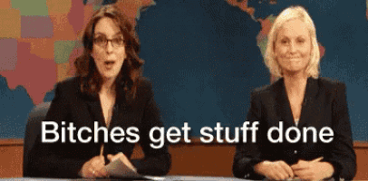 two women are sitting at a desk with the words " bitches get stuff done " behind them