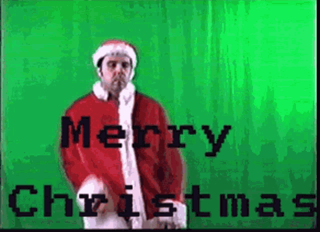 a man in a santa suit is standing in front of a green screen and says merry christmas