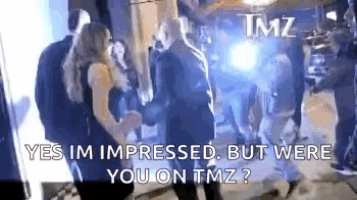 a group of people are dancing in a dark room with tmz written on the bottom .