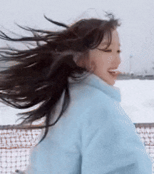 a woman with long hair is wearing a blue jacket