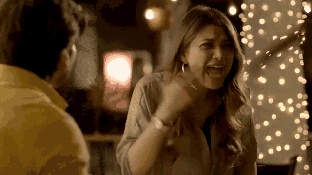 a woman in a yellow shirt is screaming at a man in a yellow shirt