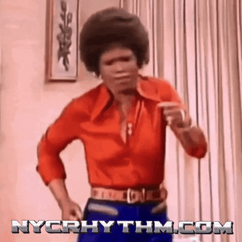 a man in a red shirt and blue pants is dancing in a room with nycrhythm.com in the corner