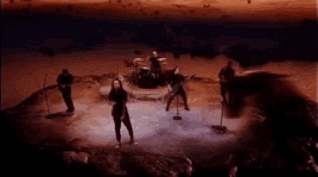 a group of people standing on top of a stage playing instruments .