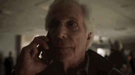 an elderly man talking on a cell phone in a dark room