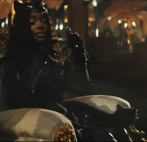 a woman in a catwoman costume sits on a chair