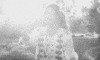 a black and white photo of a woman holding a bird in her hand .