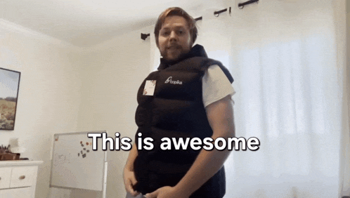 a man wearing a black vest that says this is awesome on it
