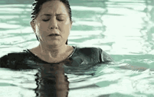 a woman is swimming in a swimming pool .
