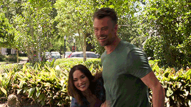 a man is giving a woman a piggyback ride in the park .