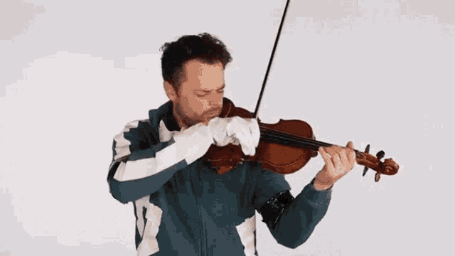 a man in a blue and white jacket is playing the violin