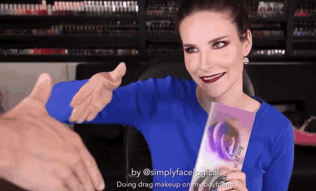 a woman in a blue shirt is holding a book that says simplyfacelogical