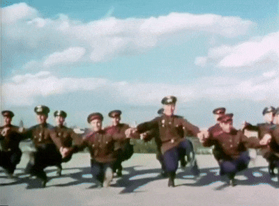 a group of men in uniforms are dancing in a line