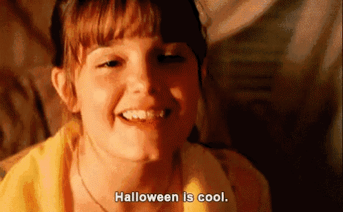 a girl in a yellow shirt is smiling and saying halloween is cool .