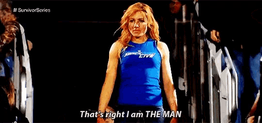 a woman in a blue tank top is dancing in front of a crowd and says `` that 's right i am the man ''