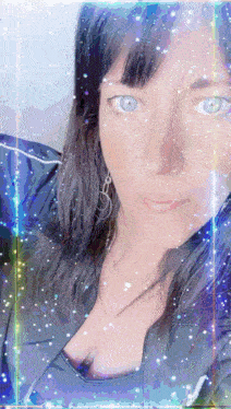 a close up of a woman 's face with sparkles around it