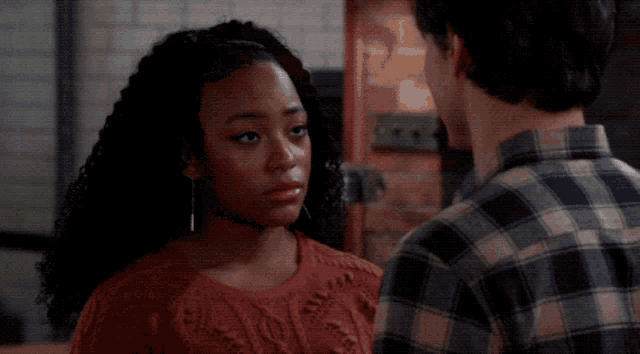 a man and woman are looking at each other and the woman is wearing earrings