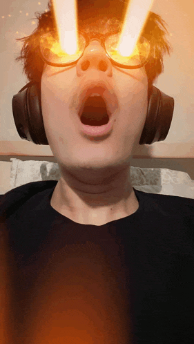 a man wearing glasses and headphones with his mouth wide open