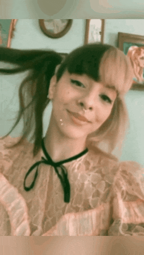 a woman with pigtails and a nose ring is smiling