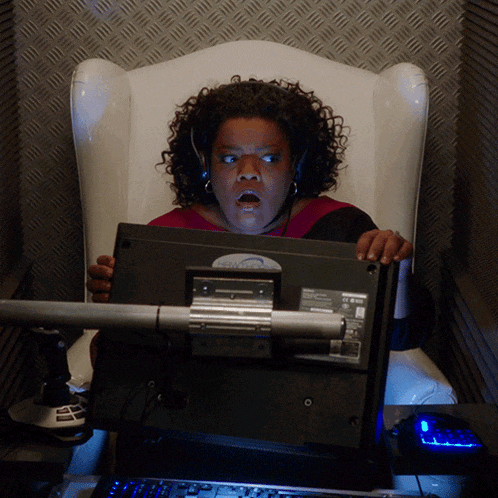 a woman sitting in a chair looking at a dell computer monitor