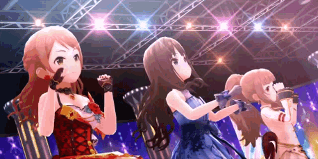 three anime girls are standing on a stage in front of a crowd .