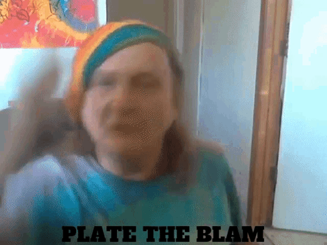 a man wearing a rainbow hat and a blue shirt says " plate the blam "