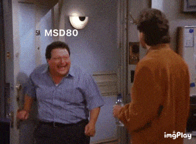 two men are standing in front of a door with the number 5a on it
