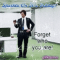 a man in a suit and tie is standing in an office looking at his phone and says forget who you are .