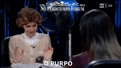 a woman in a wig is talking to another woman in front of a screen that says no perditempo forum