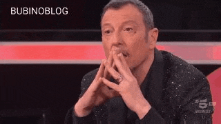a man in a black jacket is making a funny face with his hands .