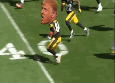 a football player with donald trump 's face on his jersey is being tackled on the field .