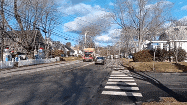 a red truck is driving down a street with a pepsi sign on the side of it