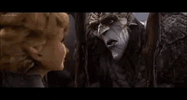 a couple of monsters are standing next to each other and one of them is holding a flower in his mouth .