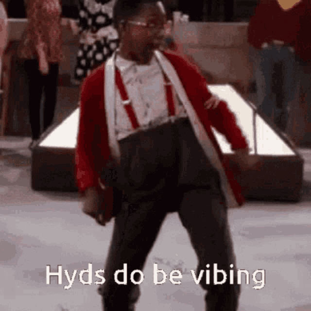a man in a red jacket and suspenders is dancing with the words hyds do be vibing above him