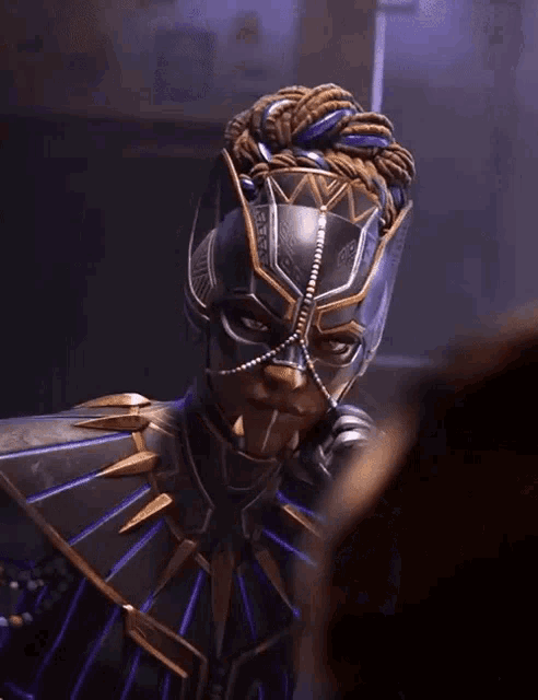a person wearing a black and gold costume with a mask on their face