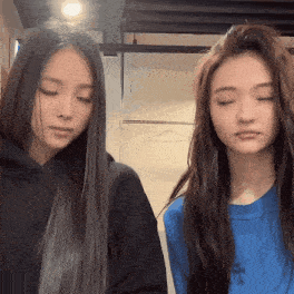 two girls with long hair are standing next to each other with their eyes closed