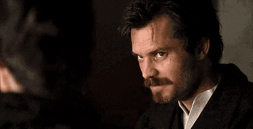 a man with a beard is talking to another man .