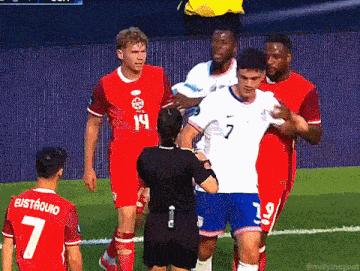 a soccer player with the number 7 on his jersey talks to a referee