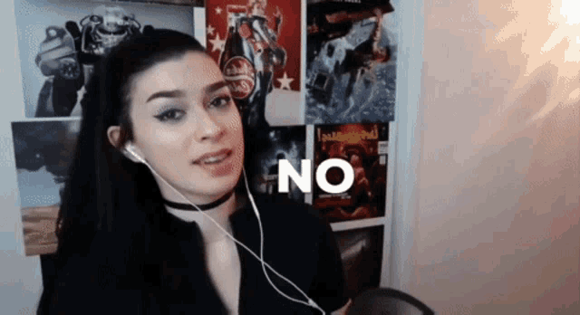 a woman wearing headphones and a choker says no in front of a wall of posters