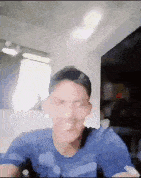 a man wearing a blue shirt is making a funny face