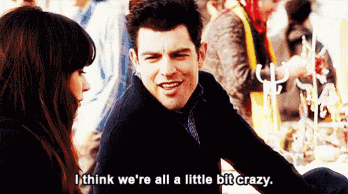 a man and a woman are sitting at a table and the man says i think we 're all a little bit crazy .