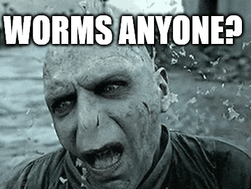 a black and white photo of voldemort from harry potter with the words `` worms anyone ? '' on his face .