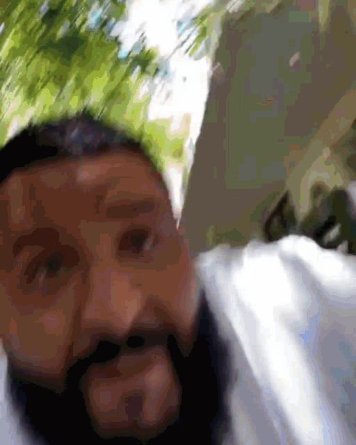 a man with a beard is wearing a white shirt and looking at the camera