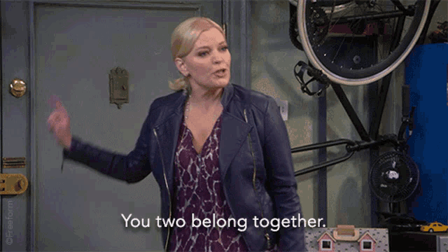 a woman standing in front of a door with the words you two belong together
