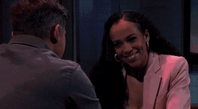a man and a woman are looking at each other and the woman is wearing a pink jacket