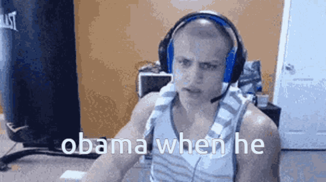 a man wearing headphones is sitting in front of a punching bag and says obama when he .