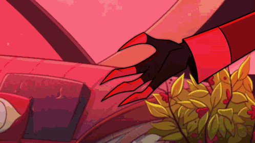 a close up of a person 's hand wearing a glove with long red claws .