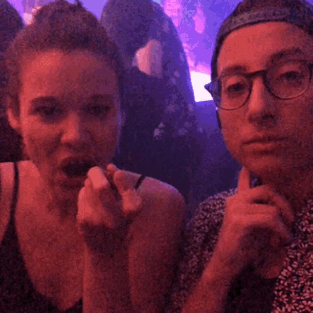 a man and a woman are sitting next to each other in a dark room