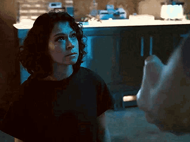 a woman in a black t-shirt is looking up at something